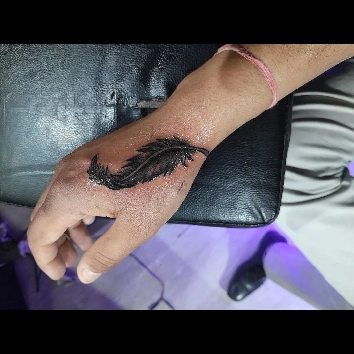 18 Tatuajes de plumas de élite en la mano: Prácticos símbolos de libertad